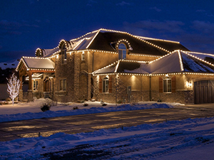 C9 Christmas lights decorate the front eaves and rooftop of this home.