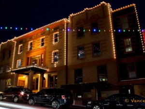 This old brick building is outlined with Christmas lights.