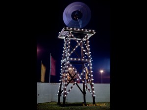 A windmill tower at the entrance to a subdivision.