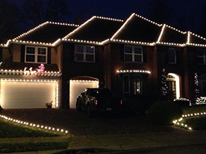 The rooftops and ridges of this home are lit with Christmas lights.